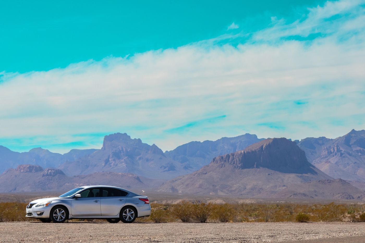 Automóvil plateado en un paisaje de montañas; fotografía referencial